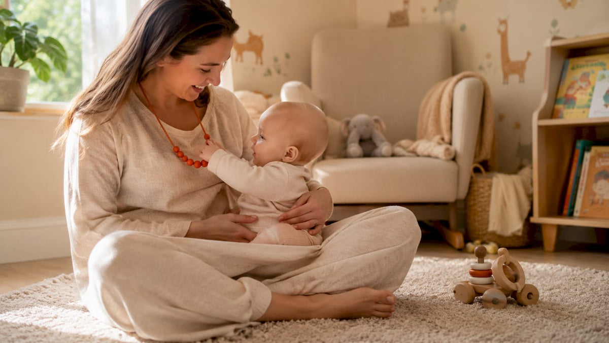 Mother wearing teething necklace holding baby